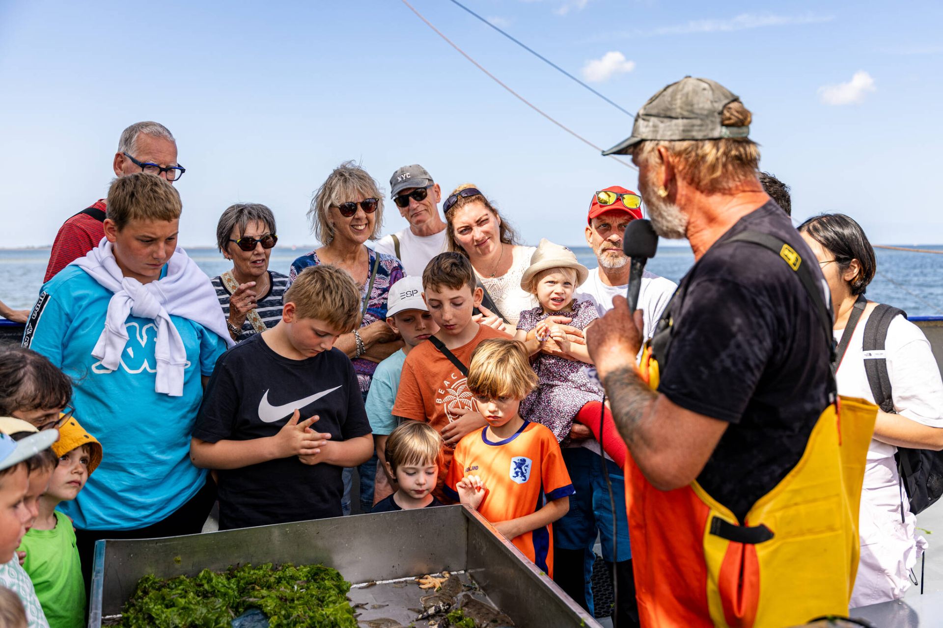 Schipper vertelt aan groep gasten over de vangst tijdens het garnalen vissen op Texel